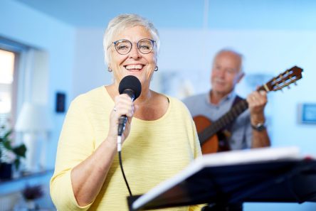 Glas senior kvinde med briller synger i mikrofon
