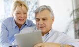 Seniormand og seniorkvinde ser på ipad.