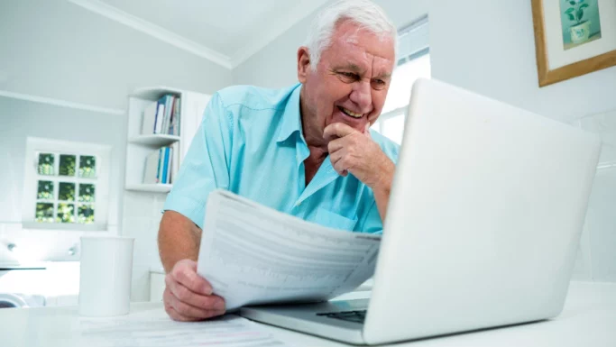 En ældre pensionist tjekker måske oplysninger om sin fødevarecheck fra Folketinget.