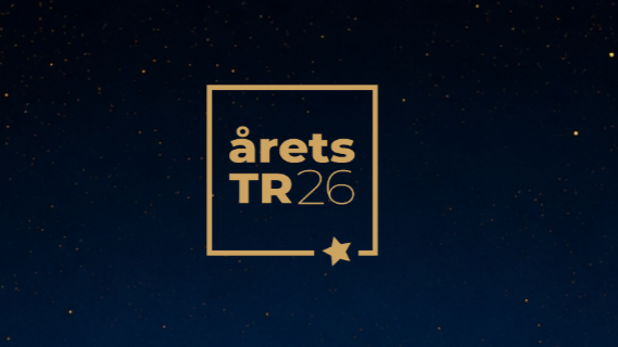 Guldtekst »årets TR 26« inden for en firkantet ramme med en lille stjerne i nederste højre hjørne, på en mørkeblå baggrund med diskrete, spredte prikker, der ligner stjerner – til ære for de engagerede ildsjæle på arbejdspladsen.