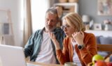 En mand og en kvinde kigger overrasket på en bærbar computer, mens de gennemgår deres pension.