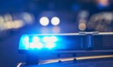 Om natten lyser en klarblå politilysbjælke på taget af et køretøj og minder dermed om de løbende bestræbelser på at forebygge svindel og beskytte mod CPR-læk.