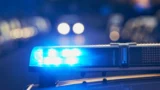 Om natten lyser en klarblå politilysbjælke på taget af et køretøj og minder dermed om de løbende bestræbelser på at forebygge svindel og beskytte mod CPR-læk.