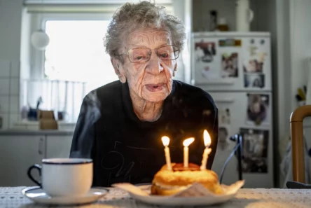 Kirsten, 112 år, puster tre lys ud på en lille fødselsdagskage og markerer dermed et øjeblik i Danmarks historie.