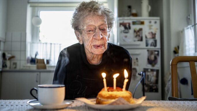 Kirsten, 112 år, puster tre lys ud på en lille fødselsdagskage og markerer dermed et øjeblik i Danmarks historie.
